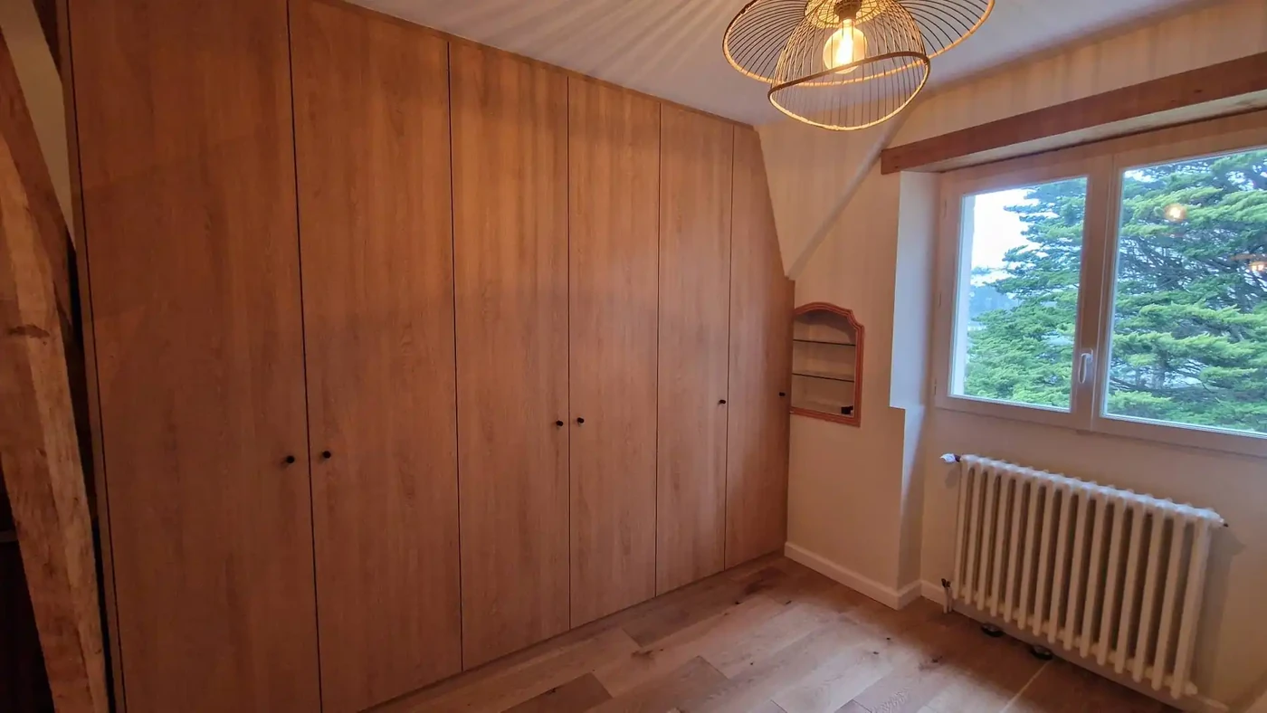Réalisation d'un dressing sur mesure en panneaux mélaminé imitation chêne avec ses penderies escamotables et ses tiroirs
